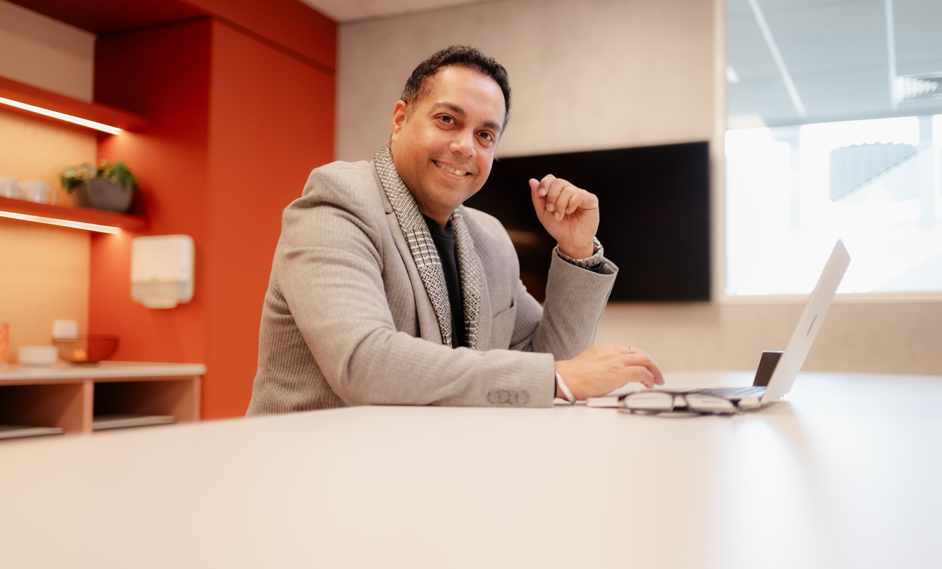 Bobby Singh, Director and CEO of Wise Healthcare, smiling at his desk